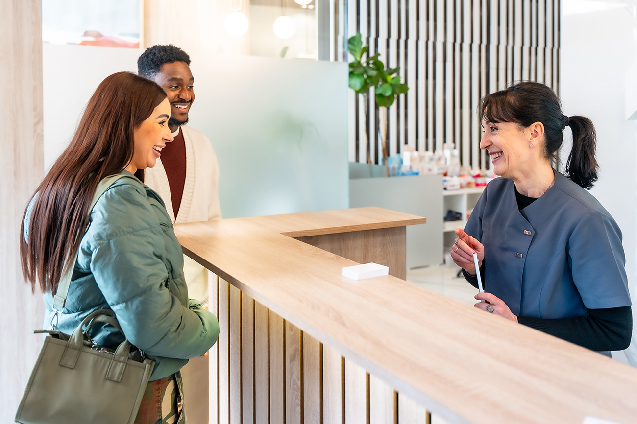 Patient welcomed at a dental office reception desk